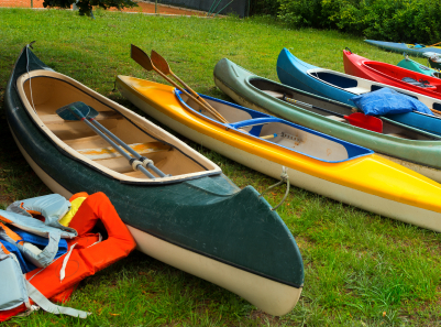 row of colorful canoes on grass