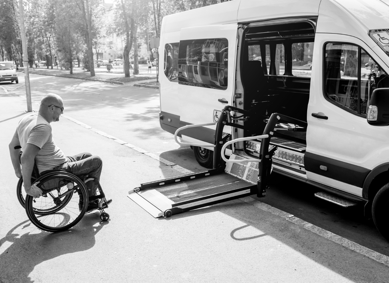 a man in a wheelchair boarding a van via wheelchair lift